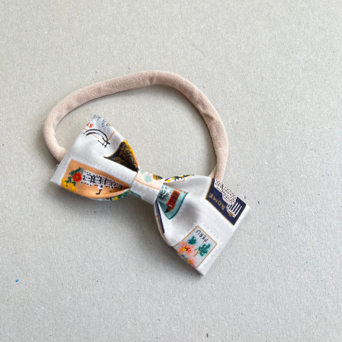 WORLD TRAVELLER RUBY BOW HEADBAND in STONE